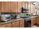 Bright kitchen featuring wood cabinets, stainless steel appliances, and tile backsplash at 9104 Stromboli Ct, Kissimmee, FL 34747