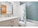 Bright bathroom featuring blue subway tile, white vanity, and shower with decorative curtain at 1016 Seminole Creek Dr, Oviedo, FL 32765
