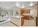 Open kitchen featuring an island with a sink, white countertops, and wood cabinetry adjacent to the Gathering room at 1016 Seminole Creek Dr, Oviedo, FL 32765