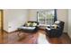 Comfortable living room with hardwood floors, a large window with blinds, and a black leather sofa set at 1016 Seminole Creek Dr, Oviedo, FL 32765