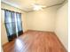 This is an empty bedroom featuring neutral tones, hardwood floors, and natural light from the window at 10255 Cody Ln, Orlando, FL 32825