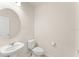 This light and airy powder room features a pedestal sink, modern fixtures, and neutral paint at 10959 Vesper Aly, Orlando, FL 32829