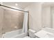 Bright bathroom featuring a shower-tub combo with neutral tile surround, a white vanity and a framed mirror at 10959 Vesper Aly, Orlando, FL 32829