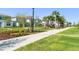 A lovely community area with sidewalks, benches, green grass, trees, and red outdoor chairs to relax on at 10959 Vesper Aly, Orlando, FL 32829