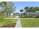 A well-maintained green space with sidewalks, lawns, palm trees, other trees and shrubs at 10959 Vesper Aly, Orlando, FL 32829