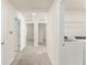 Upstairs hallway with three doorways and a laundry room with a white washer and dryer at 10959 Vesper Aly, Orlando, FL 32829