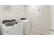 Bright laundry room featuring a modern washer and dryer set, wire shelving, and tile flooring at 10959 Vesper Aly, Orlando, FL 32829
