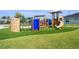 Colorful community playground with climbing structures, slides, and swings, all set on a soft, green turf surface at 10959 Vesper Aly, Orlando, FL 32829