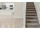 Staircase featuring neutral-colored carpet and a view into the kitchen with stainless appliances at 10959 Vesper Aly, Orlando, FL 32829
