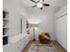 Bright bedroom featuring a ceiling fan, built-in shelving, and an orange chair atop a colorful rug on hardwood floors at 1109 Pavia Dr, Apopka, FL 32703