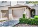 Townhome exterior featuring a two-car garage and well-maintained landscaping at 1109 Pavia Dr, Apopka, FL 32703