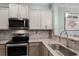Close-up of the updated kitchen, displaying granite countertops, stainless steel appliances, and ample cabinetry at 1109 Pavia Dr, Apopka, FL 32703