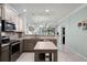 Open kitchen features stainless appliances, granite countertops, island, and view to the living area at 1109 Pavia Dr, Apopka, FL 32703