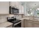 Modern kitchen featuring stainless steel appliances, granite countertops, and stylish cabinets at 1109 Pavia Dr, Apopka, FL 32703