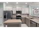 Modern kitchen boasts stainless steel appliances, light cabinets, and a functional center island at 1109 Pavia Dr, Apopka, FL 32703