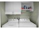 Well-organized laundry room with a white washer, dryer and storage at 1109 Pavia Dr, Apopka, FL 32703