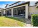 Exterior view of a screened patio with outdoor seating and green yard at 1109 Pavia Dr, Apopka, FL 32703