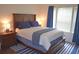 Comfortable bedroom with a wooden bed frame, a blue and white striped rug, and matching curtains at 12212 Wild Iris Way # 106, Orlando, FL 32837