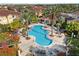 Large pool area surrounded by tropical landscaping and comfortable seating at 12212 Wild Iris Way # 106, Orlando, FL 32837