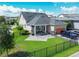 Backyard view featuring manicured lawn, fenced yard, covered patio with seating, and a two-car garage at 13347 Gabor Ave, Orlando, FL 32827