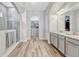 Bright bathroom featuring dual sinks, quartz countertops, a walk-in shower, and access to the walk-in closet at 13347 Gabor Ave, Orlando, FL 32827