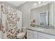 Neutral bathroom with granite countertop vanity and floral shower curtain at 13347 Gabor Ave, Orlando, FL 32827