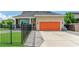 Inviting single-story home featuring a vibrant orange garage door and well-manicured lawn and walkway at 13347 Gabor Ave, Orlando, FL 32827