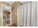 Bathroom showing a shower with curtain, tiled floor, and open door at 13609 Sky Blue Ct, Orlando, FL 32828