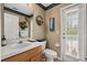 Neutral bathroom with a single vanity, a toilet, and door leading to the outside at 13609 Sky Blue Ct, Orlando, FL 32828