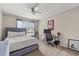 A bright bedroom with a bed, computer desk, and window with curtains at 13609 Sky Blue Ct, Orlando, FL 32828