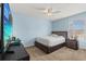 A well-lit bedroom boasts blue walls, a platform bed, ceiling fan, and a window at 13609 Sky Blue Ct, Orlando, FL 32828