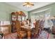Dining room with ornate wooden table, chairs, china cabinet, and large bay window at 13609 Sky Blue Ct, Orlando, FL 32828