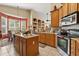 Bright kitchen featuring wood cabinets, granite countertops, stainless steel appliances, and eat-in breakfast nook at 13609 Sky Blue Ct, Orlando, FL 32828