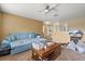 Living room featuring a blue sofa, wooden coffee table, and open space with natural light at 13609 Sky Blue Ct, Orlando, FL 32828