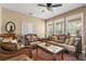 Bright living room with large windows, ceiling fan, and ornate sofas and a decorative rug at 13609 Sky Blue Ct, Orlando, FL 32828