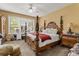 Main bedroom with a four-poster bed, dressing table, and a ceiling fan at 13609 Sky Blue Ct, Orlando, FL 32828