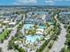 Aerial view featuring multiple sparkling pools, lush landscaping, and recreational facilities in the community at 13913 Hahn Ln, Orlando, FL 32827