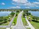 Scenic aerial view features a beautiful road leading into the community, flanked by lush greenery and a serene lake at 13913 Hahn Ln, Orlando, FL 32827