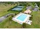 The community pool is nestled between tennis courts, a clubhouse, and lush greenery at 14155 Portrush Dr, Orlando, FL 32828