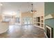 Bright and airy living room with a ceiling fan, built-in shelving, and sliding doors to the pool area at 14155 Portrush Dr, Orlando, FL 32828