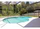 An enclosed pool with clear water is surrounded by a white fence and green trees at 14155 Portrush Dr, Orlando, FL 32828