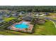Aerial view of a community pool and playground surrounded by trees and homes at 1541 Tali Ln, Mount Dora, FL 32757