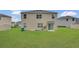 A large backyard with green lawn behind a two-story home with sliding glass doors at 1541 Tali Ln, Mount Dora, FL 32757