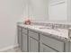 Bright bathroom featuring a double vanity with grey cabinets and speckled granite countertops at 1541 Tali Ln, Mount Dora, FL 32757