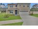 Charming two-story home featuring a well-manicured lawn, attached two car garage, and inviting blue front door at 1541 Tali Ln, Mount Dora, FL 32757
