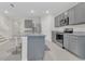 Modern kitchen with grey cabinets, granite counters, stainless steel appliances, and an island with bar seating at 1541 Tali Ln, Mount Dora, FL 32757