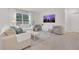 Bright living room boasts a large window, neutral furniture, light tile flooring, and a stylish media center at 1541 Tali Ln, Mount Dora, FL 32757