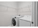 Clean laundry room featuring a modern washer/dryer set and wire shelving for storage at 15651 Kinnow Mandarin Ln, Winter Garden, FL 34787