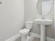 Half bath featuring a pedestal sink, toilet, and neutral wall color at 16460 Silver Brook Way, Winter Garden, FL 34787