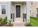 A cozy front porch featuring a decorative railing, beautiful planters, and a welcoming entrance door at 16460 Silver Brook Way, Winter Garden, FL 34787